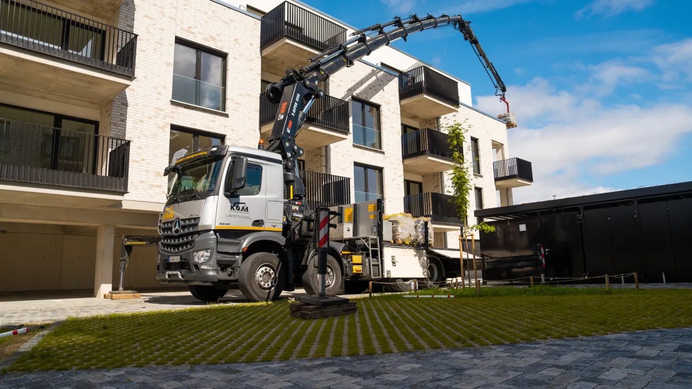 Mercedes-Benz Arocs mit ausgefahrenem Ladekran an der Wohnanlage